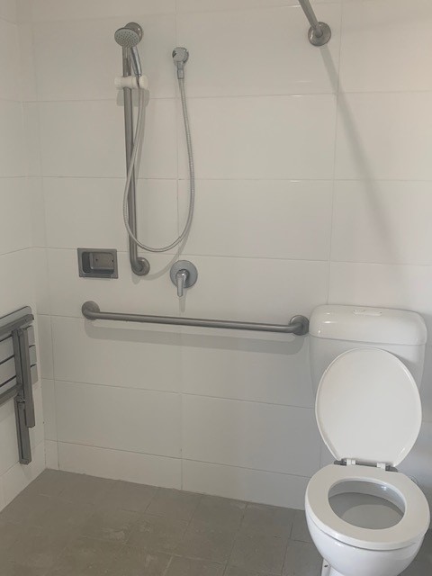 An image showing the bathroom included with the bedroom of the property, there is a shower head, and toilet visible