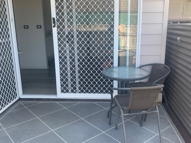 An image showing an outdoor table and seating area outside of the bedroom