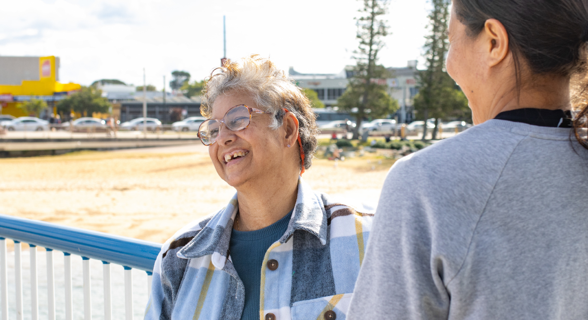 Two people are laughing together on a pier