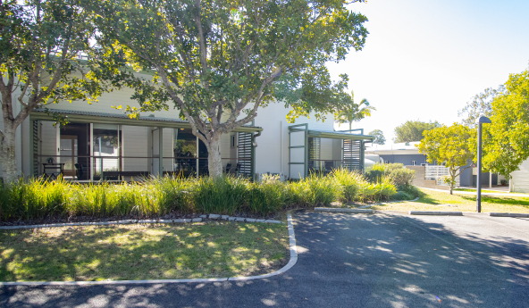 Outside of a set of homes showing lots of trees and car parking